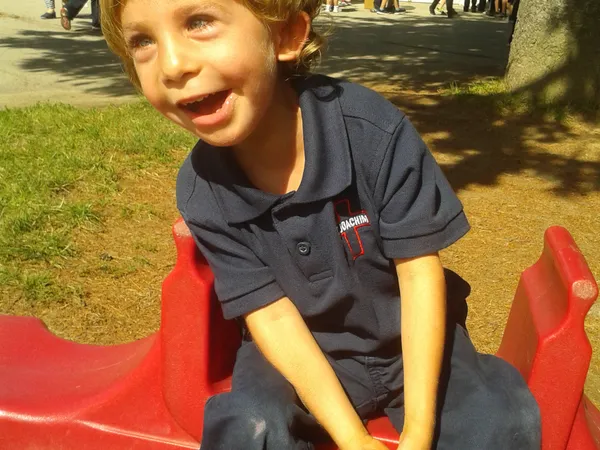 Ryan laughing on the playground slide at school