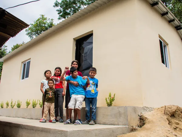 Darwin, his mother and siblings standing on the front step of their finished home