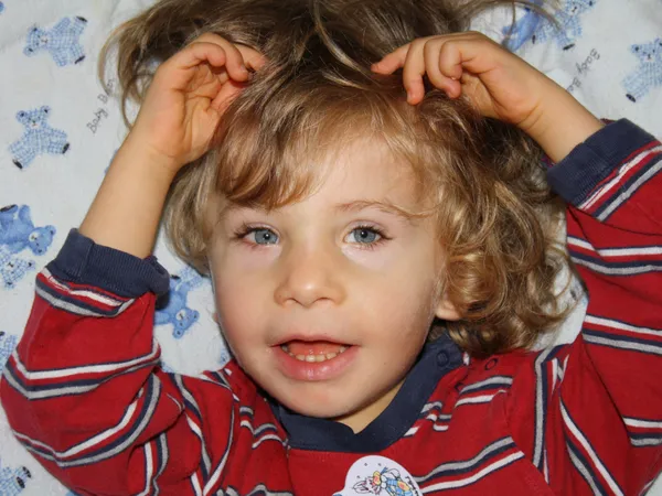 Ryan lying on his bed in striped pyjamas, hands in his hair