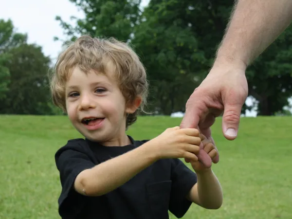 Ryan in the park, holding a hand and grinning