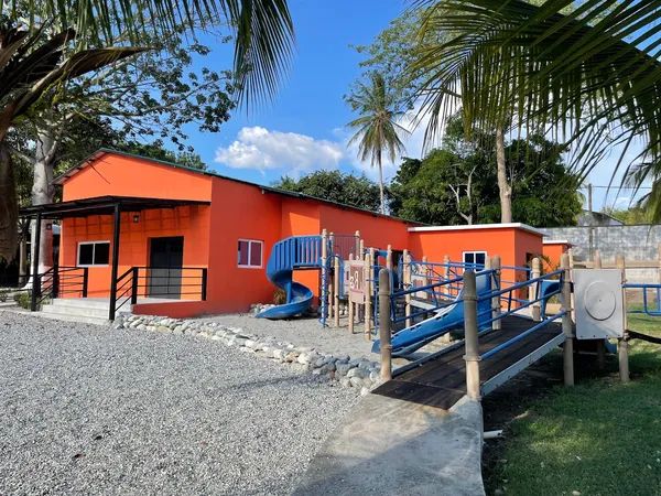 The side of Ryan’s Place with the blue playground slides and ramps beside it